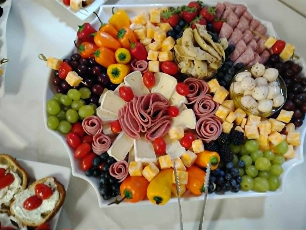 Charcuterie board with cured meats, peppers, and grapes