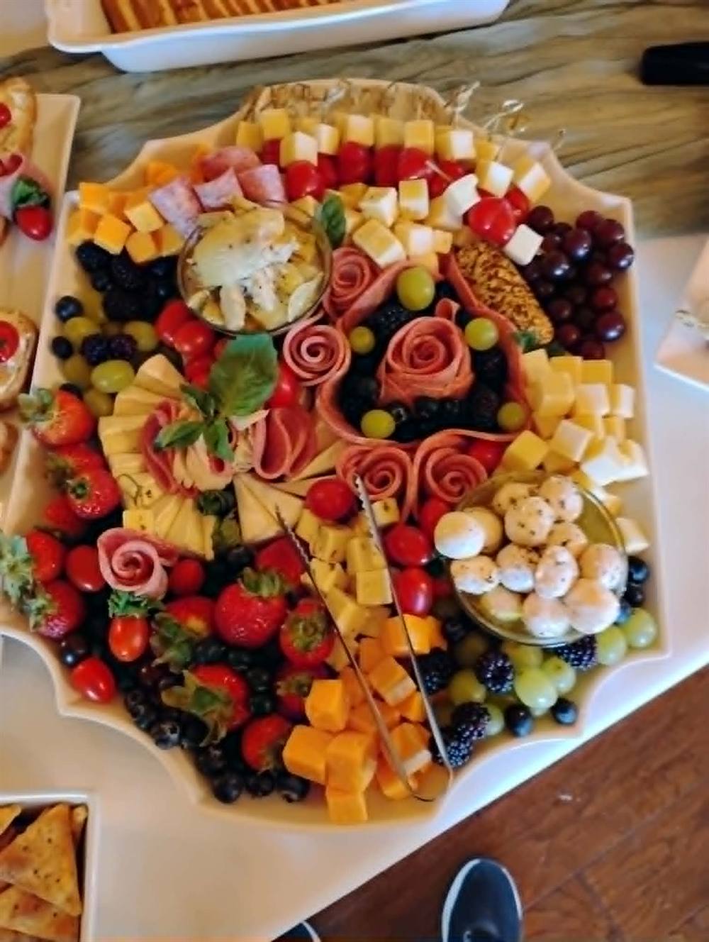 Charcuterie board with rolled salami roses, prepared for a catered event